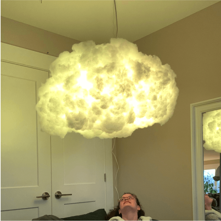 Hanging and lit cloud lamp with a person underneath